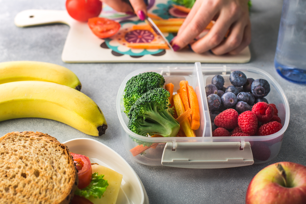 Mother giving healthy lunch for school in the morning